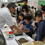 日本の伝統食材であるかつお節削りを体験。かつお節削りは初体験という子どもも多い